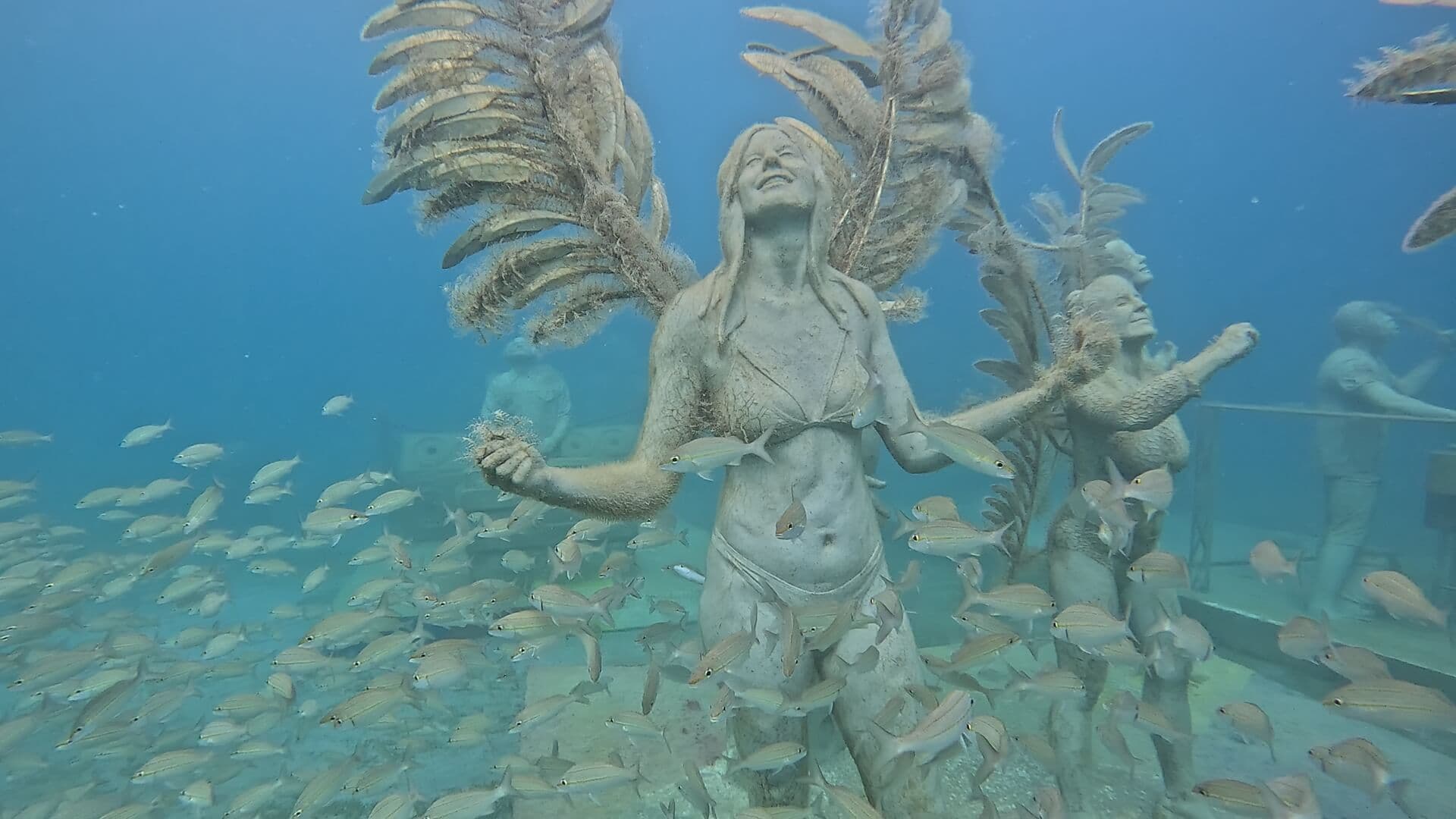 Carnival dance sculptures surrounded by fish